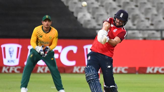 England's Dawid Malan (R) hits a six as South Africa's captain and wicketkeeper Quinton de Kock (R) looks on during the third T20 international cricket match between South Africa and England at Newlands stadium in Cape Town, South Africa, on December 1, 2020. (Photo by Rodger BOSCH / AFP)