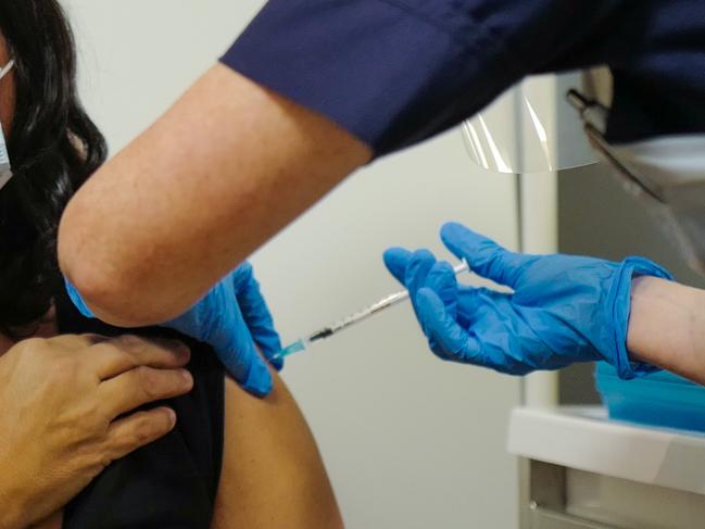 TRURO, ENGLAND - DECEMBER 09: Deborah Cartmel receives the Covid-19 vaccine as the Royal Cornwall Hospital begin their vaccination programme on December 9, 2020 in Truro, United Kingdom. More than 50 hospitals across England were designated as covid-19 vaccine hubs, the first stage of what will be a lengthy vaccination campaign. NHS staff, over-80s, and care home residents will be among the first to receive the Pfizer/BioNTech vaccine, which recently received emergency approval from the country's health authorities. (Photo by Hugh Hastings/Getty Images)