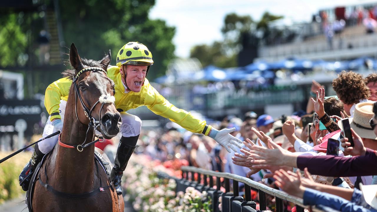 Jockey Mark Zahra high-fiving the crowd at the 2023 Melbourne Cup after winning with horse Without A Fight, trained by Anthony Freedman. Picture: David Caird