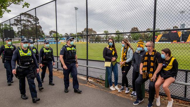 Fans walk past with police patrolling the Punt Road oval Picture: Jason Edwards