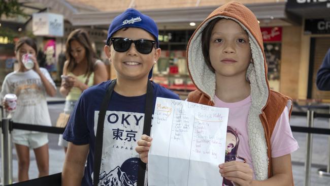 Siblings Bailey Mai, 8, and Maddy Mai, 10, with their shopping list. Picture: Emma Brasier