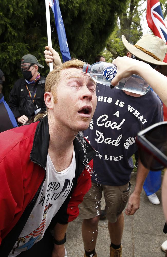 An anti-lockdown protester has capsicum spray washed from his eyes at the Shrine of Remembrance in Melbourne. Picture: NCA NewsWire / Daniel Pockett