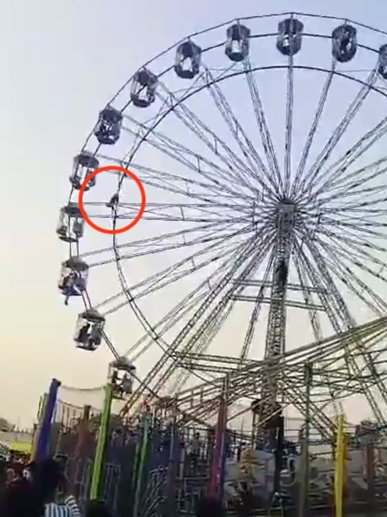 A video grab of a 13-year-old dangling 60-feet from the ground after falling out of her Ferris wheel pod. Picture: Jam Press