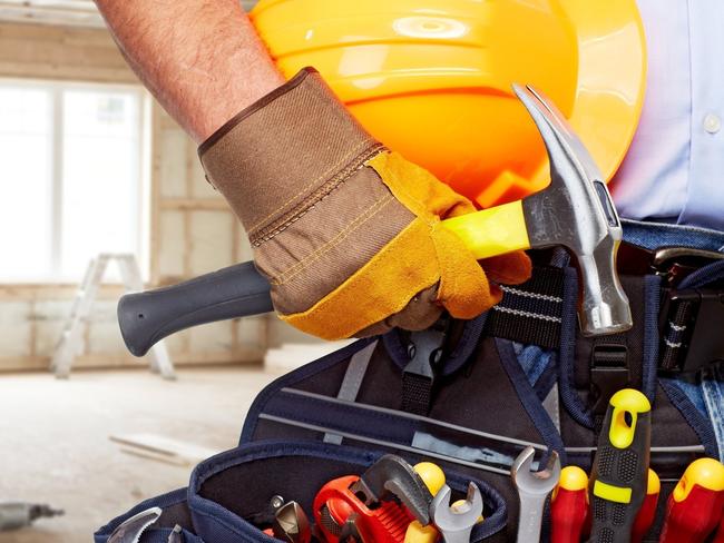 Builder handyman with construction tools. House renovation background.