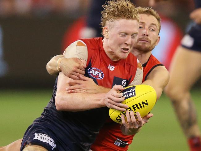 MELBOURNE, AUSTRALIA - APRIL 05: Devon Smith of Essendon tackled Clayton Oliver of the Demons during the round three AFL match between the Melbourne Demons and the Essendon Bombers at Melbourne Cricket Ground on April 05, 2019 in Melbourne, Australia. (Photo by Michael Dodge/Getty Images)