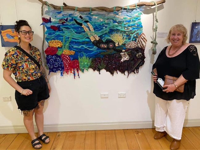 Unit area coordinator Kelly Morgan (right) and teacher’s aide Margie Farrell (left) pose with a students artwork.