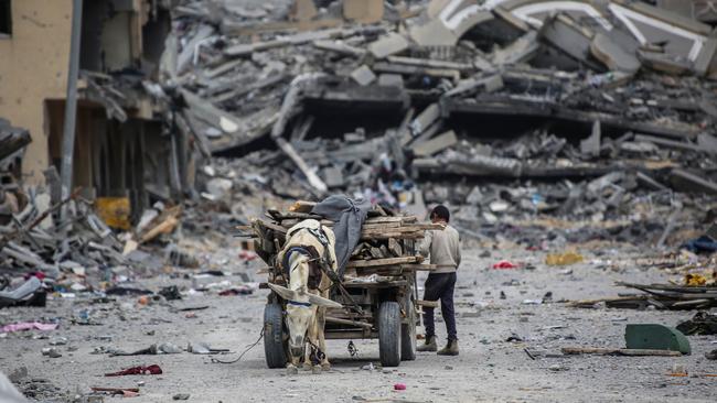 A young man fills a cart amid the ruins in Khan Younis. Picture: Getty Images