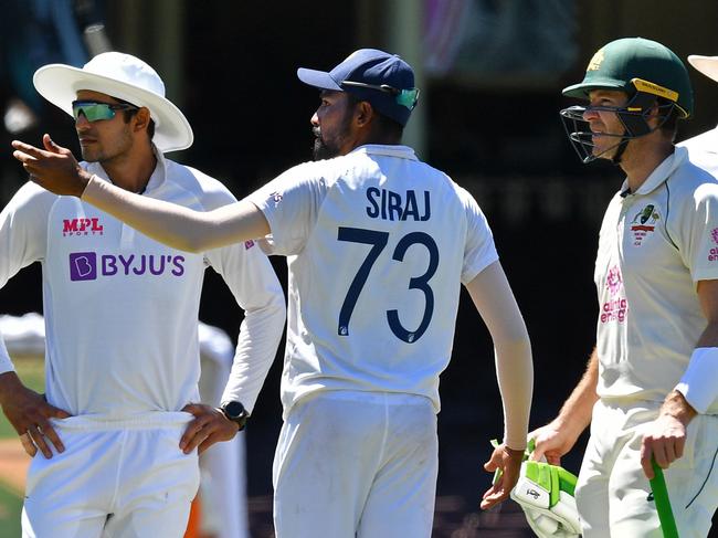 India's Mohammed Siraj (C) gestures next to Australia's captain Tim Paine (2R) as the game was halted after allegedly some remarks were made by the spectators on the fourth day of the third cricket Test match between Australia and India at the Sydney Cricket Ground (SCG) in Sydney on January 10, 2021. (Photo by Saeed KHAN / AFP) / -- IMAGE RESTRICTED TO EDITORIAL USE - STRICTLY NO COMMERCIAL USE --