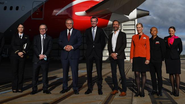 Qantas CEO Alan Joyce (fifth left), Prime Minister Scott Morrison (middle left), NSW Premier Dominic Perrottet (middle right) and Jetstar CEO Gareth Evans (sixth right) with Qantas and Jetstar employees during a press conference at the Qantas Jet Base at Sydney Airport. Picture: NCA NewsWire/Bianca De Marchi