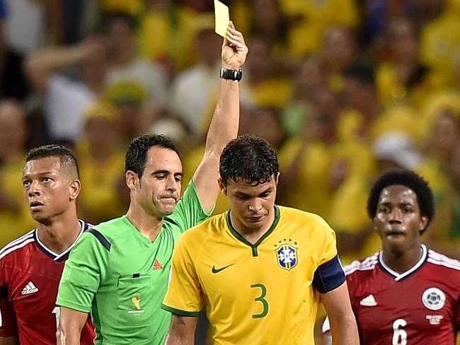 Brazil's defender and captain Thiago Silva (C) receives a yellow card from Spanish referee Carlos Velasco Carballo (2L) during the quarter-final football match between Brazil and Colombia at the Castelao Stadium in Fortaleza during the 2014 FIFA World Cup on July 4, 2014. AFP PHOTO / FABRICE COFFRINI