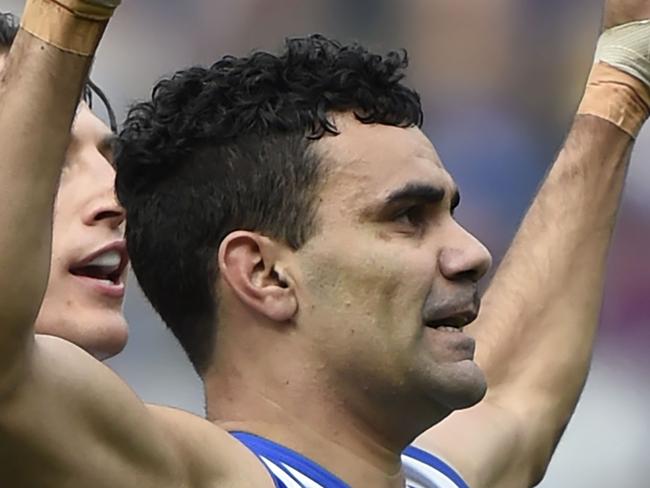 Ben Jacobs (left) and Lindsay Thomas (centre) of the North Melbourne Kangaroos celebrate a goal by Thomas during their round nineteen AFL match at MCG in Melbourne on Sunday, August 9, 2015. (AAP Image/Mal Fairclough) NO ARCHIVING, EDITORIAL USE ONLY