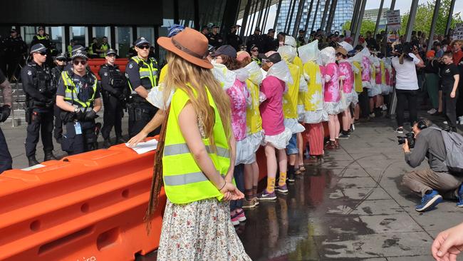 Protesters stand in ponchos and goggles outside the IMRC in Melbourne. Picture: Mark Schliebs