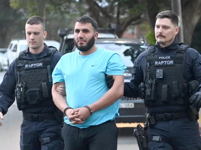 Embargoed for The Daily Telegraph. Pictured in the blue shirt is Ali Elmoubayed.  SYDNEY, AUSTRALIA - June 23, 2023: Police officers fro RAPTOR and supporting agencies raid the homes and arrest three men in SydneyÃs West. Picture: Jeremy Piper