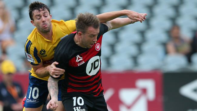 Wanderers striker Simon Cox fends off the Mariner’s Tommy Oar last weekend. Picture: Getty Images