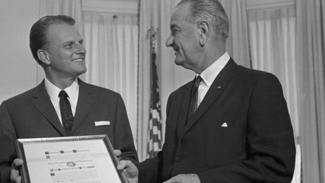 Former president Lyndon Johnson presents the Man of the Year award of the Big Brothers organisation to Billy Graham at the White House in 1966. Picture: AP.