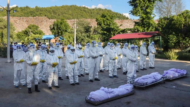 Volunteers pray in front of the bodies of people who died from Covid-19 in Mandalay, Myanamar. Picture: AFP