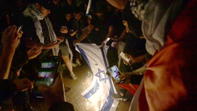 SYDNEY, AUSTRALIA - NewsWire Photos OCTOBER 9, 2023: ÃRally For A Free PalestineÃ protest burn the Israeli flag on the forecourt of The Sydney Opera House  in Sydney following the recent outbreak of war between Israel and Palestine.Picture: NCA NewsWire / Jeremy Piper