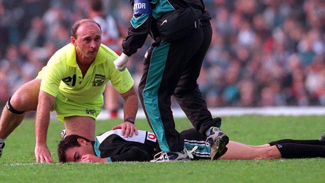 Nathan Eagleton receives attention after collapsing in the middle of Football Park.