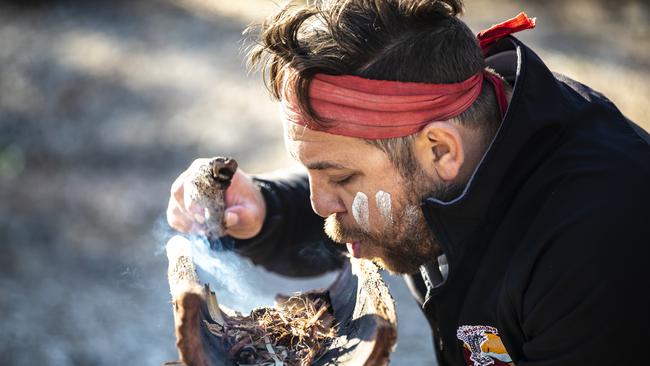 Aboriginal guide Dwayne Bannon-Harrison performing a smoking ceremony during a traditional welcome on a Ngaran Ngaran Culture Awareness tour. Picture: Destination NSW.