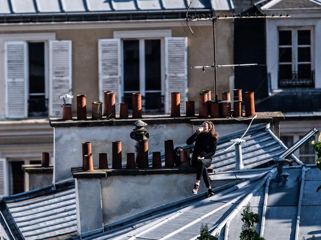 A Parisian woman sits alone on her rooftop. Picture: AFP.