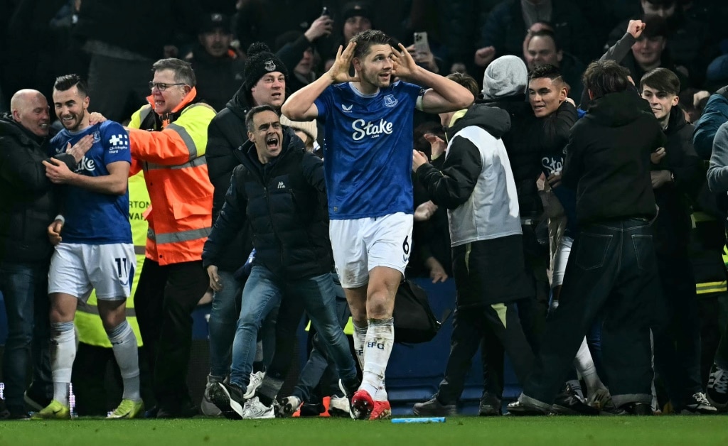 Late, late show: James Tarkowski is mobbed by fans as he celebrates scoring Everton's second goal