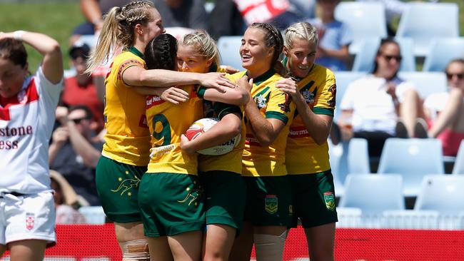 Meg Ward celebrates a try with Jillaroos teammates.