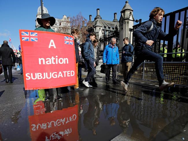 A pro-Brexit activist holds a placard as he demonstrate outside of the Houses of Parliament in London on March 14, 2019, before a further Brexit vote. - British MPs will vote today on whether to ask the European Union for an extension to the March 29 Brexit deadline, with the whole process mired in chaos. (Photo by Tolga AKMEN / AFP)