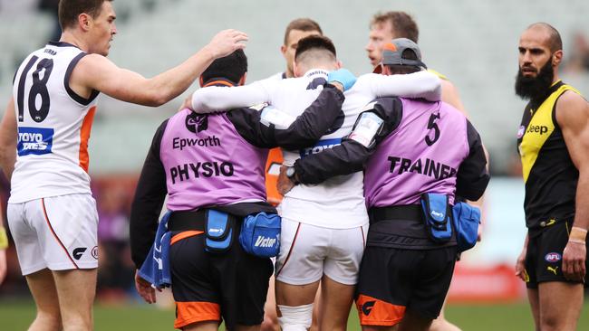 Stephen Coniglio of the Giants is carried off the ground after injuring his leg. Picture: Getty Images