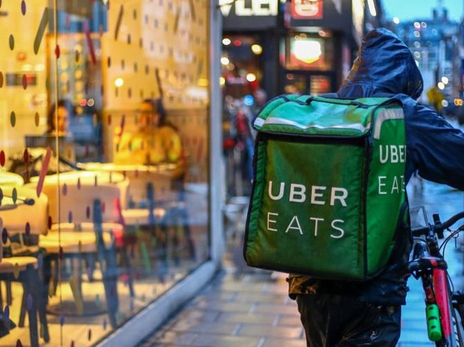 A food delivery courier working for Uber Eats, operated by Uber Technologies Inc., pushes a bicycle past a restaurant in the Soho district of London, U.K., on Friday, Oct. 2, 2020. Covid-19 lockdown enabled online and app-based grocery delivery service providers to make inroads with customers they had previously struggled to recruit, according the Consumer Radar report by BloombergNEF. Photographer: Hollie Adams/Bloomberg