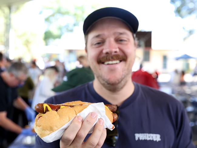 Lee Tavener has a democracy sausage at Marrickville Public School. Picture: Damian Shaw