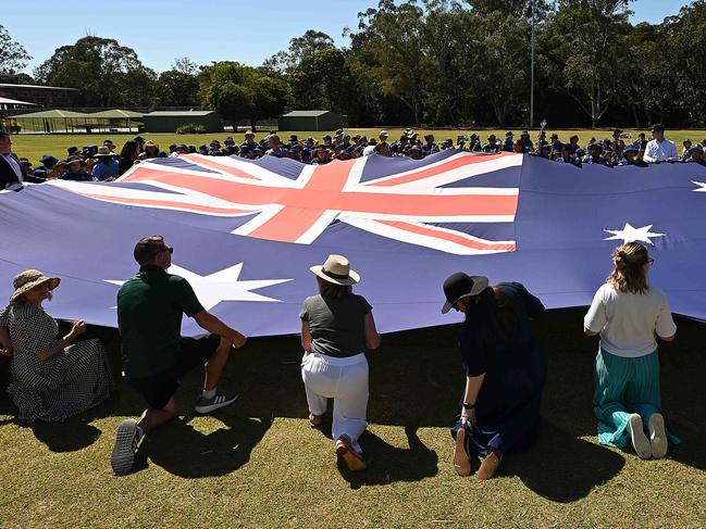 30/9/2024: Students from Jindalee State School help The Speaker of the House of Representatives and Federal Member for Oxley. the Hon Milton Dick MP unrolling and holding up the iconic 12.8m x 6.4m Australian Parliament House Flag, on the school oval, Jindalee, Brisbane. The school is the first site of the Australian Parliament House Flag Roadshow .pic: Lyndon Mechielsen/Courier Mail