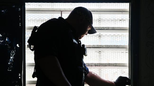 An officer examines a window frame. Picture: Richard Dobson