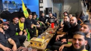 Mohamed Dhan (second left) with men waving the green and yellow Hezbollah flag with members of his personal development group, The Tribe Where Everyman Belongs, in Iraq on August 23, 2024.