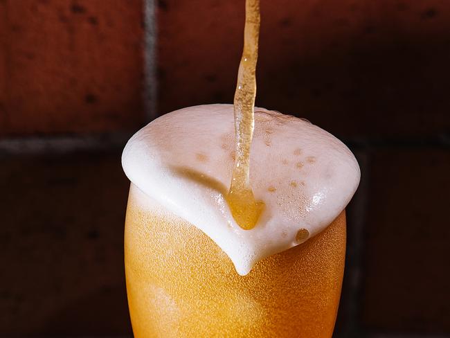 Pouring beer into glass close up