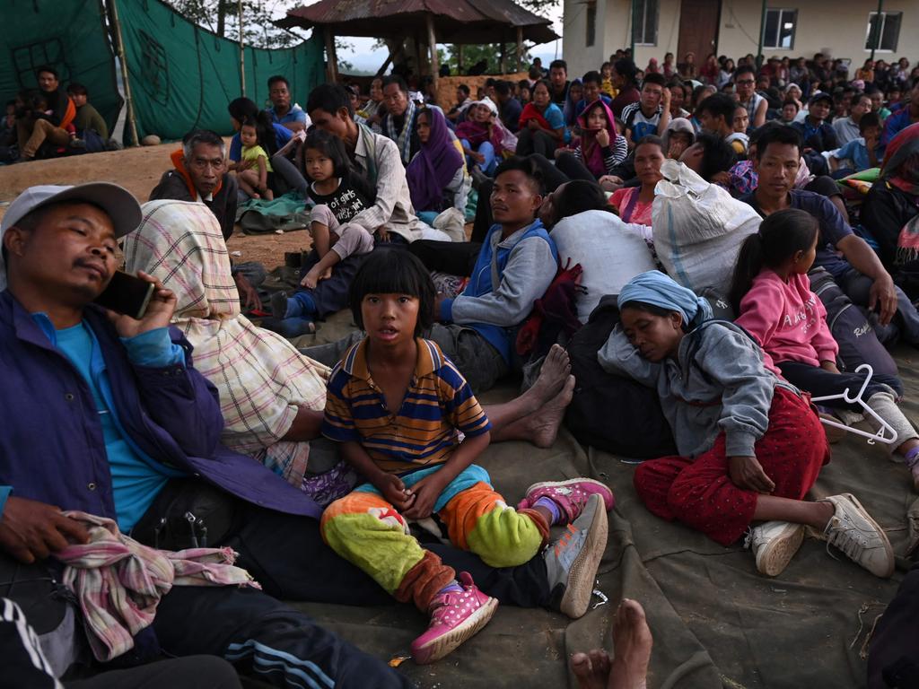 People wait at a temporary shelter in a military camp after being evacuated by the Indian army.