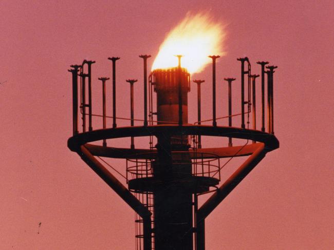 Santos Ltd's oil and gas operations at Moomba, SA, 20 May 1994.  The burn-off tower silhouetted against an Outback sunrise.