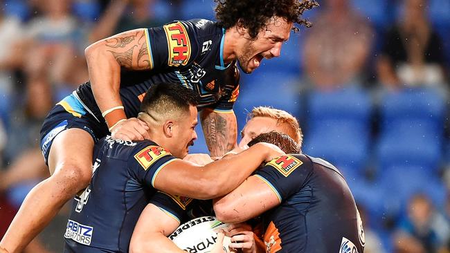 Kevin Proctor jumps on a pack of Titans teammates as AJ Brimson celebrates scoring a try. Picture: Matt Roberts/Getty Images