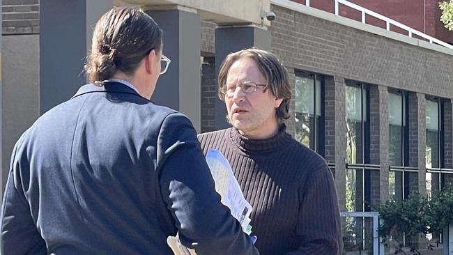 John Bursic speaking to his lawyer outside Sutherland Local Court on Friday after defending an allegation he supply drugs to another patient at a hospital. Picture: Ashleigh Tullis