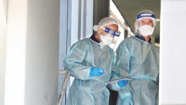 DHHS medical staff are seen at a public housing block in Broadmeadows linked to the Grade 5 student. Picture: David Crosling