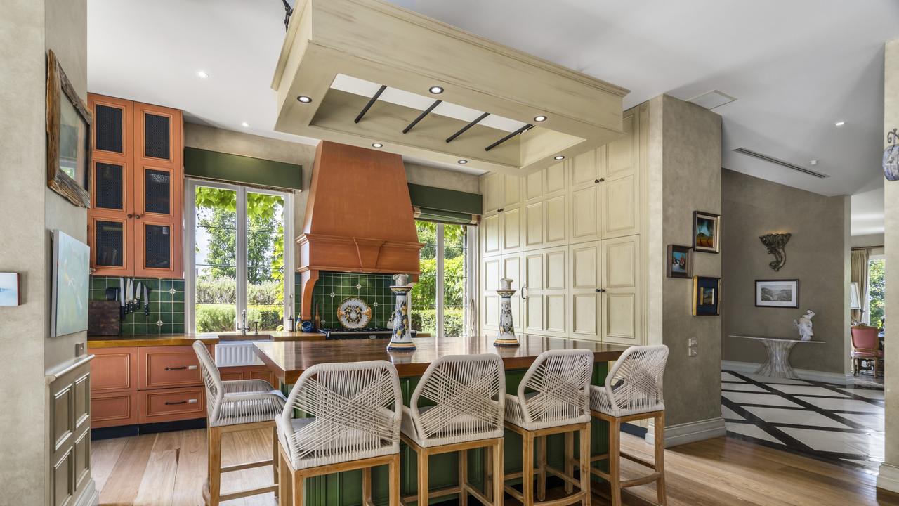 The provincial-style kitchen features natural timber benchtops, integrated appliances and a Falcon stove.