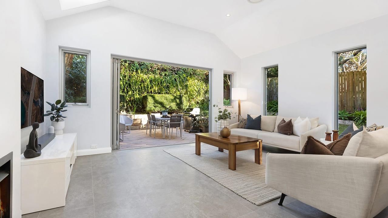 A large open-plan living room opens to an outdoor terrace.