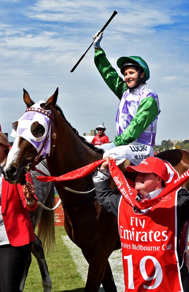 Michelle Payne salutes the crowd on Prince Of Penzance in the 2015 Melbourne Cup, with horse led by strapper and brother Stevie. Picture: Jay Town.