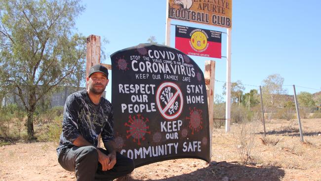 Jason King, from Santa Teresa, crouches beside his family's entry into the 'Car Bonnet Art Competition.' Picture: SISTER LIZ WEIMERS