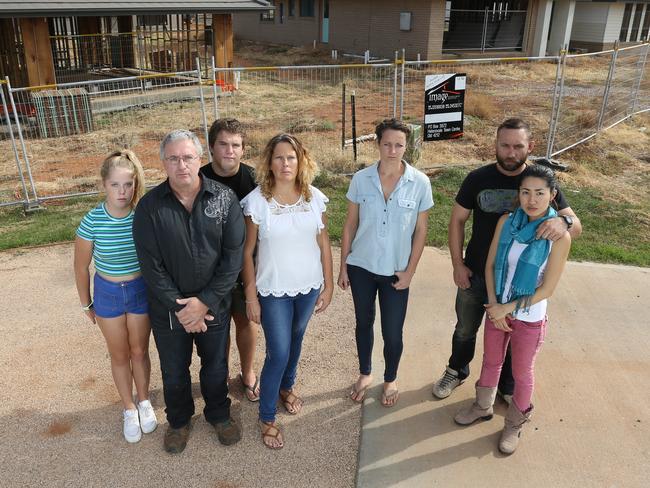 The interstate investors taken for a ride. Pictured in front of there unfinished homes in Parkes, NSW are L-R, Peter and Leanne Montebello with kids, Paige and Jack (from Perth), Pippa DeBeaux (from Darwin) and Bronson and Satomi Hetet (from Gold Coast). Picture: Brad Newman