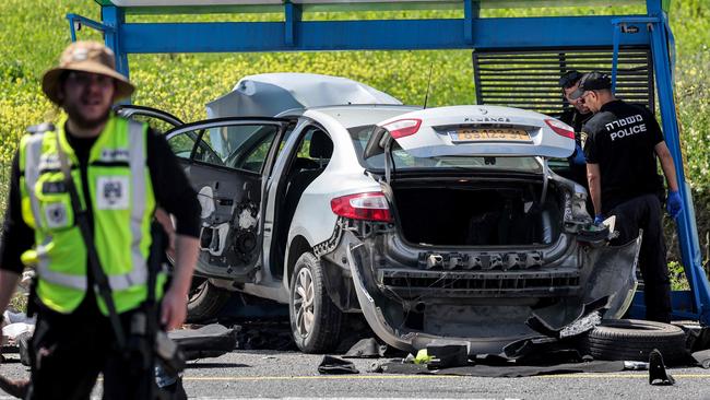 Security forces inspect a damaged vehicle at the scene of an attack at the Tishbi road junction about 30 kilometres southeast of Haifa in northern Israel on March 24, 2025. Israeli police said on March 24 that officers "neutralised" a gunman who carried out an attack in the country's north which first responders said killed one man and wounded another. The attack is the first in Israel since a ceasefire with Hamas in Gaza broke down after Israeli forces resumed bombings on the Palestinian territory on March 18. (Photo by Jack GUEZ / AFP)