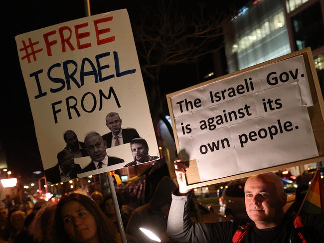 Protesters lift placards during an anti-government demonstration in Israel's central city of Tel Aviv, on February 17, 2024, amid the ongoing conflict in the Gaza Strip between Israel and the Palestinian militant Hamas movement. (Photo by JACK GUEZ / AFP)