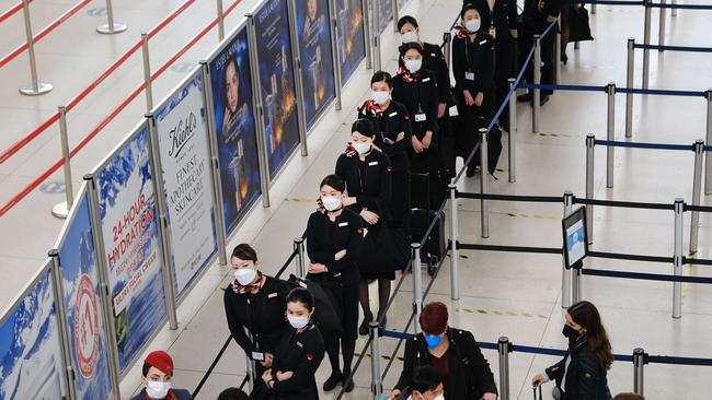 Airline staff and passengers wait to be screened at John F. Kennedy Airport on April 19, 2022 in New York City. Spencer Platt/Getty Images/AFP