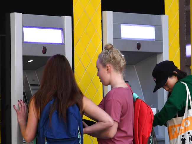 Customers use a Commonwealth Bank (CBA) ATM in Brisbane, Thursday, August 3, 2017. The Commonwealth Bank has been accused of a systemic failure to comply with anti-money laundering and counter-terrorism financing laws. The federal government's financial intelligence unit AUSTRAC on Thursday launched civil penalty proceedings in the Federal Court, accusing the lender of more than 53,700 contraventions of law. (AAP Image/Dan Peled) NO ARCHIVING