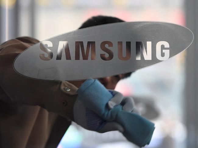 (FILES) In this file photo taken on March 24, 2017 a worker cleans a glass door showing the logo of Samsung Electronics at a company's building in Seoul. Samsung Electronics reported a 52 percent jump in its first quarter net profit on April 26, 2018 thanks to strong demand for memory chips and its latest flagship smartphone. / AFP PHOTO / JUNG Yeon-Je