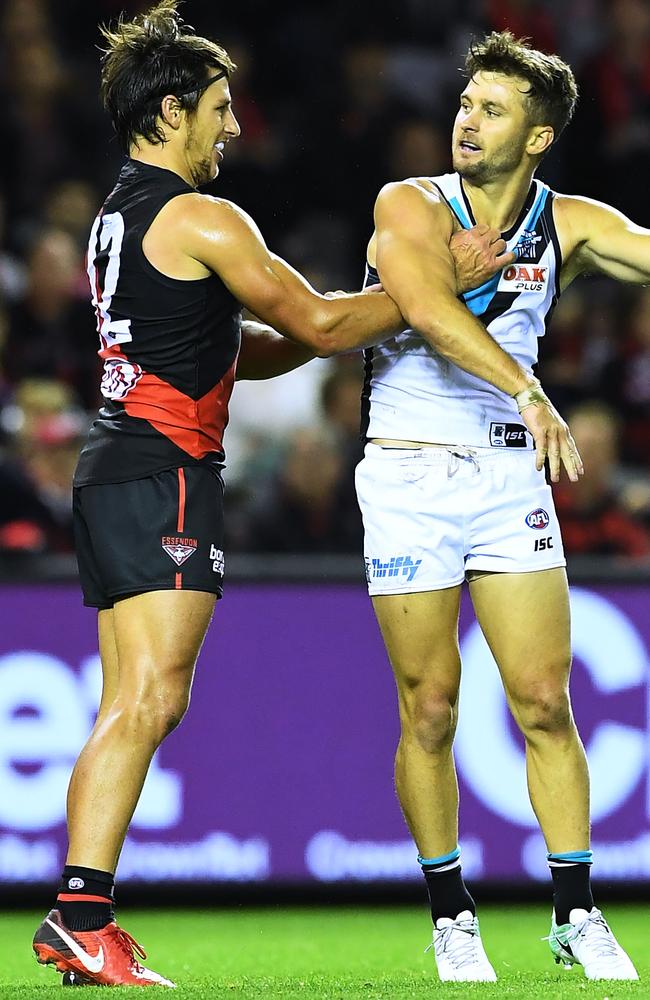 Sam Gray of Port Adelaide has a swing at Mark Baguley of the Bombers.